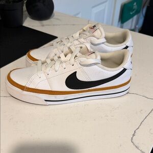 Nike White Sneakers with Black Swoosh and Gold Trim